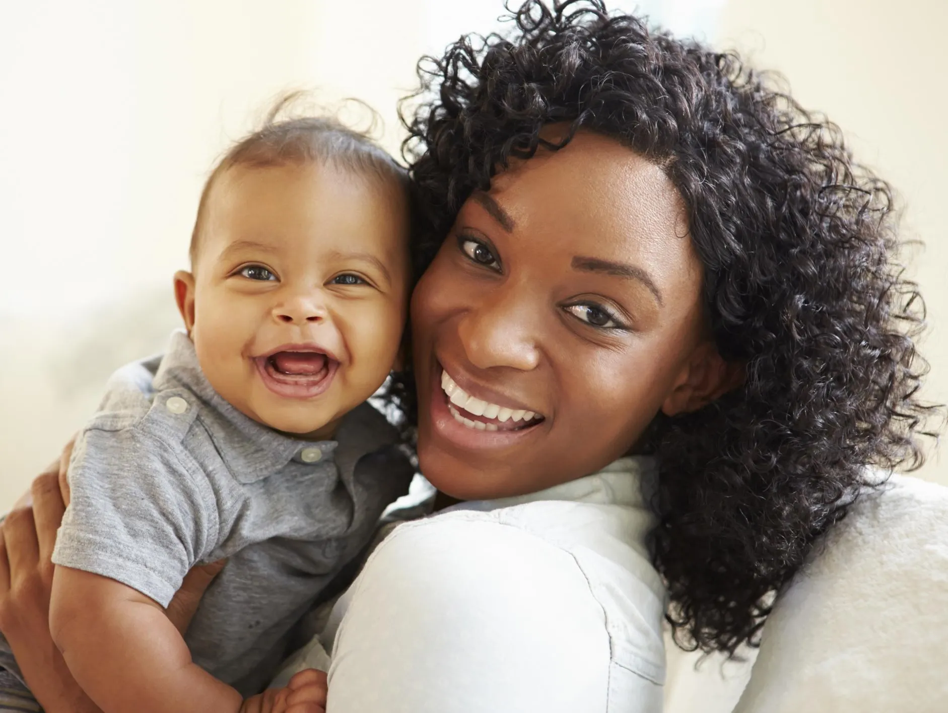 Woman with her child smiling to the camera to promote