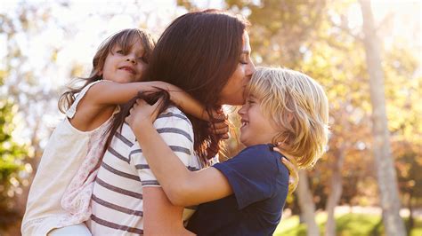 Mother embracing her children outdoors, showcasing family connection and joy, relevant to discussions on wellness and protecting children.
