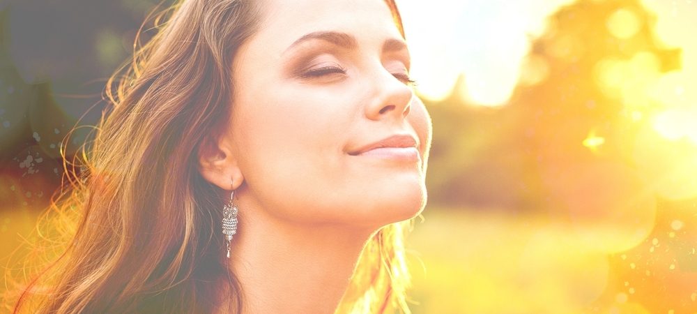 woman smiling absorbing the sun as we discuss the truth behind skin cancers - buy rife machine